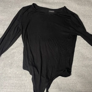 Svart långärmad body från even & odd - Snygg svart body med långa ärmar och rund hals. Perfekt för lager-på-lager eller som den är. Enkel och stilren design som passar till det mesta.