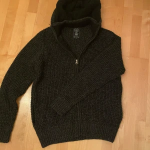 Mörkgrå stickad cardigan  - Sjukt snygg stickad cardigan/hoodie i nästan ny skick! Den är riktigt varm och perfekt för vintern. Storlek är xl men skulle säga att den passar mer som L/M. Pris kan diskuteras 