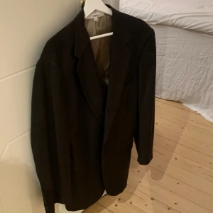 Kavaj - En kavaj med indragen midja från beyond retro x ginatricot kollektionen. Sparsamt använd. Mörk brun färg. 