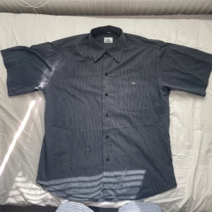 Lacoste Skjorta - Fet grå lacoste skjorta med bra passform i väldigt bra skick