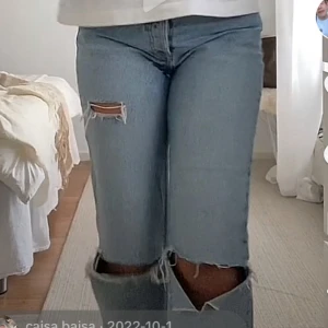Ljusa jeans med slitningar - Säljer ett par ljusa jeans med coola slitningar på knäna. De har en straight passform och är perfekta för en avslappnad stil. Jeansen är i en klassisk blå färg och ser riktigt snygga ut med en vit t-shirt eller en mysig tröja. Perfekta för både vår och höst!