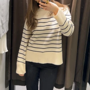 Randig tröja - Säljer denna sköna tröjan med randiga detaljer ifrån zara med en liten slits på sidorna nere. som bara är använd en gång! Så i nyskick 💞den är i Xs men passar även S/M!