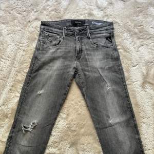 Replay Jeans med slitningar. Skick 6,5/10. Finns tecken på användning. Stolek 29/32. Modell: 180/60kg. Färg svarta/gråa. 