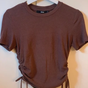 Brun ribbad t-shirt  - Ribbad  Knytning på båda sidor. Från BikBok St xs