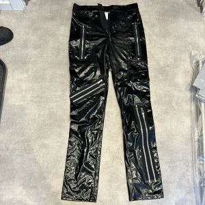 Fusk latex byxor med dragkedjor  - XS/S, Köpta begagnat så lite slitna i skrevet (inget som synd jätte väl när man har på sig) sitter väldigt tight runt midjan och låren men är lite lösare ner till vaderna. 