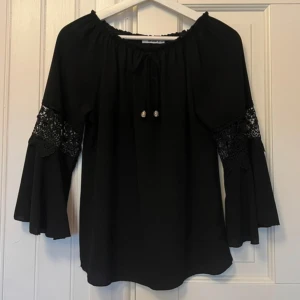 Svart blus med spets på ärmen  - Svart blus med spets på ärmen. Fint skick, endast använd någon gång. Storlek m men jag är xs/s