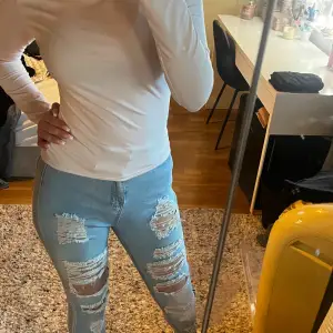 Säljer ett par ljusa jeans med slitningar. De är tighta och har en snygg passform som framhäver benen. Perfekta för en avslappnad och trendig look!