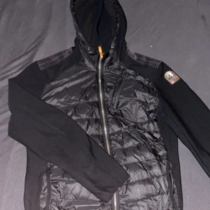 Parajumper cardigan - Warm Up - Säljer en svart Warm Up cardigan från Parajumpers. Jackan har en fet design med dragkedja och en luva. Perfekt för kyliga höst dagar när du vill hålla dig varm och bekväm. Jackan är i storlek L men passar även M. ‼️ÄNDAST SERIÖSA KÖPARE‼️