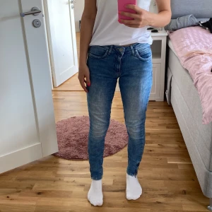 Blå jeans från ONLY - Säljer ett par snygga blå jeans från ONLY. De är skinny fit och har en klassisk femficksdesign. Jeansen har en dragkedja och knapp framtill och är i ett stretchigt material för extra komfort. Perfekta för både vardag och fest!