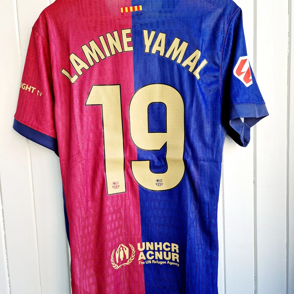 Säljer FC Barcelonas nya matchtröja för kommande säsong 2024/25 med Yamal på ryggen. Tröjan är en reprint i nyskick med emblem och patchar av högsta kvalité. Tröjan är en player version. Tajt i storleken, motsvarar mer latge än XL.. Sportswear.