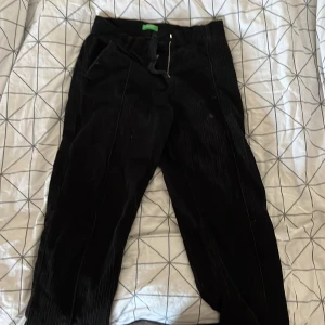 Svarta manchesterbyxor från United Colors of Benetton - Säljer ett par svarta manchesterbyxor från United Colors of Benetton. De har en klassisk design med dragkedja och knapp framtill. Perfekta för en stilren och bekväm look!