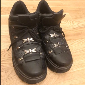 Svarta sneakers med metallspännen - Säljer ett par coola svarta sneakers med unika metallspännen och tjock sula. Har älskat dessa skor, dom är sköna och går att klä upp o ner. Ända defekten är att sulorna inuti (bara vid hälen) har blivit lite skum. Påverkar inte bekvämligheten på skorna. Storlek 8 men upplever att dom passar 40 kanske 41 ❤️