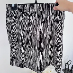 Kort kjol - En kort svart/vit kjol med fint mönster. Säljer pga att den aldrig kommit till användning. Passar bra till mig som normalt har storlek S-M i nederdelar.  Längd: 44 cm Midja: 75 cm