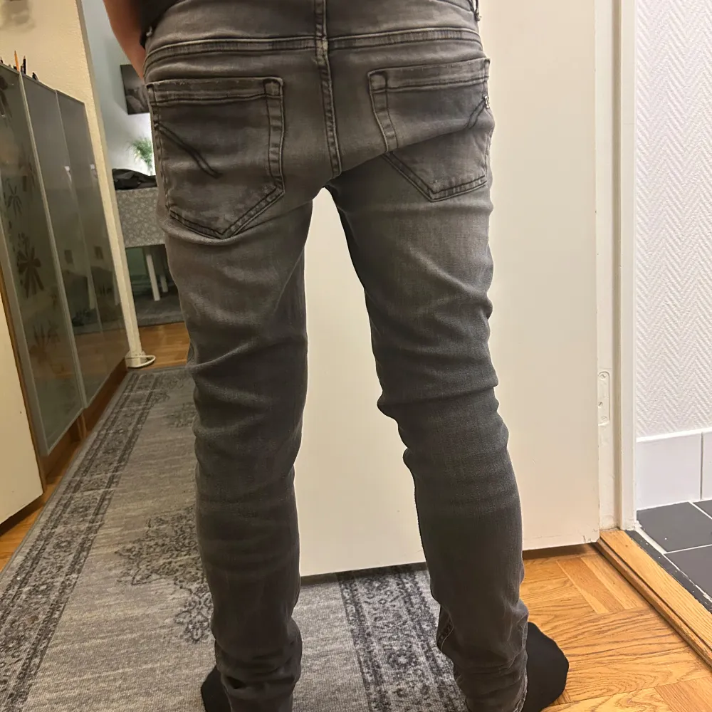 Säljer ett par grå jeans från Dondup . De är skinny fit och har en snygg, sliten look. Obs!Jeansen är Lagade se bild 5. Modellen är 175 cm och väger 68 kg.. Jeans & Byxor.