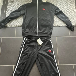 Axel arigato tracksuit  - Säljer min unika Axel arigato tracksuit. Den är i väldigt bra skick 9/10. Tröjan str L nypris 2200kr och byxorna str XL nypris 2000kr.  Tröjan - 1200 Byxorna - 950 Tillsammans 1900kr