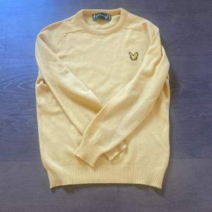 Säljer en superfin gul tröja från Lyle & Scott i 100% ull. Den har en klassisk design med rund hals och ett broderat emblem på bröstet. Perfekt för höst och vinter, och den är både varm och stilren. Passar lika bra till vardags som till lite finare tillfällen.