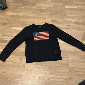 Marinblå stickad tröja från Polo Ralph Lauren - En grish🤙 stickad marin blå Ralph lauren tröja med USA flaggan på varan skickas dagen efter köpet