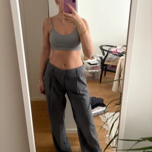 Grå byxor från Gina Tricot - Säljer ett par snygga grå byxor från Gina Tricot i storlek L. De är högmidjade och har en loose passform som ger en avslappnad stil. Perfekta för både vardag och fest! 🩶