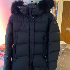 Svart savoie vinterjacka från Cedrico - En supervarm och mysig vinterjacka från Cedrico!Jackan är i toppskick och har endast använts ett par gånger. Har inga skador eller fläckar på sig. Den har en äkta svart päls som är avtagbar och bra praktiska fickor. 🫶🏼