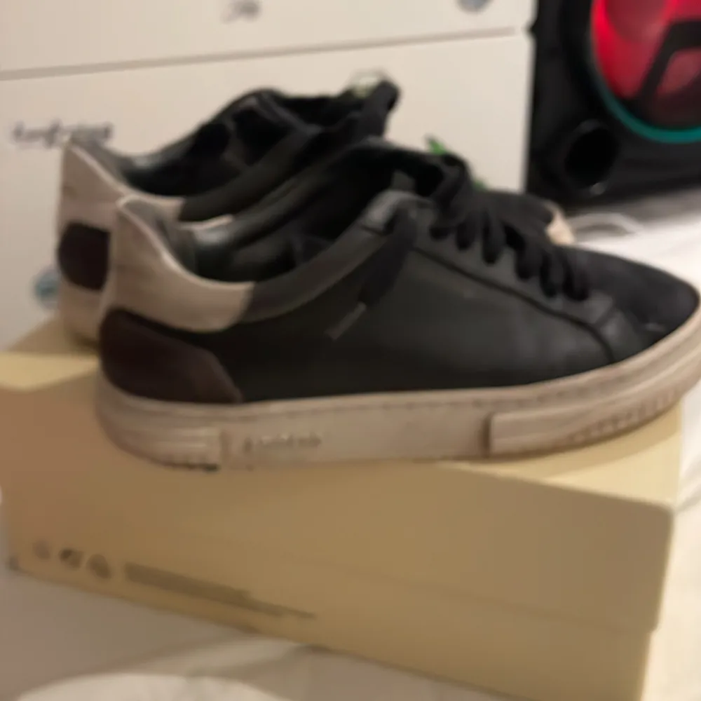 Säljer ett par svarta sneakers i bra skick med vit sula. De har snörning och en stilren design, perfekt för vardagsbruk. Skorna är bekväma och passar till de flesta outfits.. Skor.