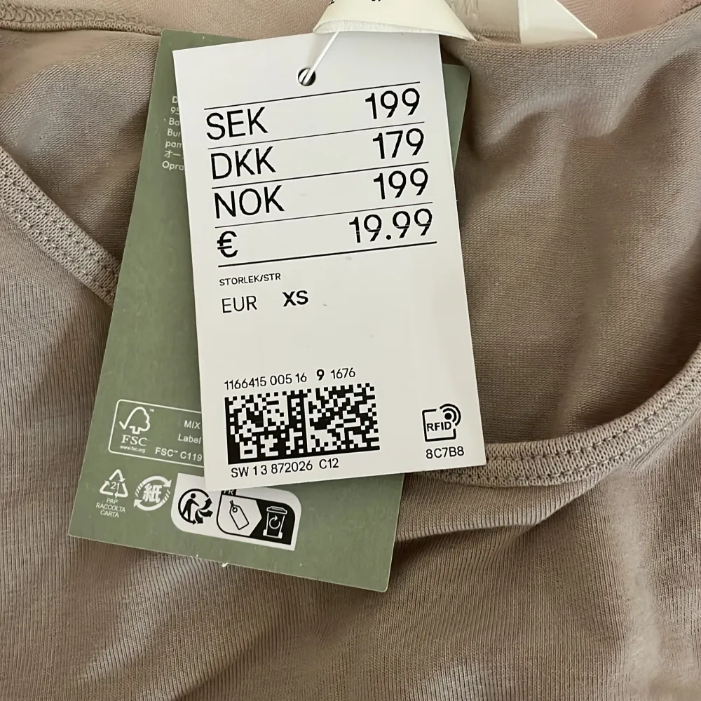 Säljer en beige t-shirt från H&M i storlek XS. Den är kortärmad och gjord i mjukt bomulls material. Den är i nytt skick med prislappen kvar.. T-shirts.