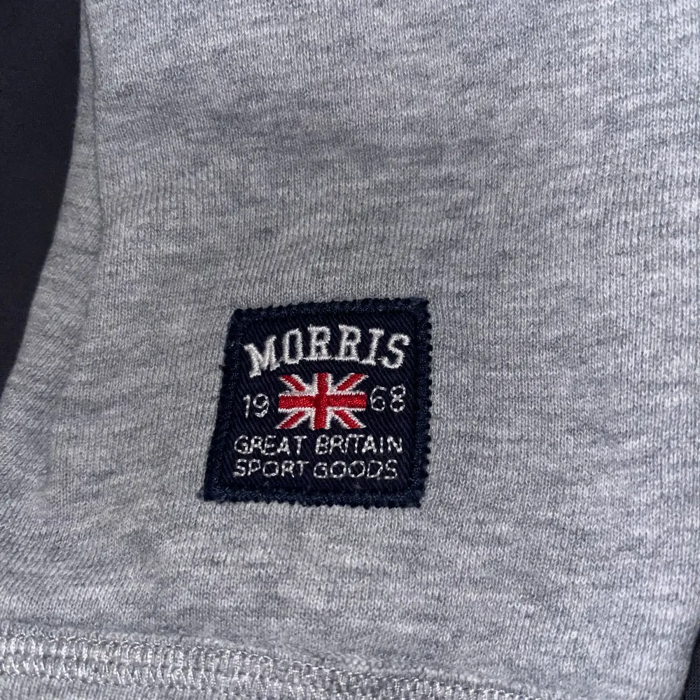 Säljer en snygg grå sweatshirt från Morris i storlek medium. Tröjan har ett klassiskt tryck med Morris-loggan och en brittisk flagga på bröstet. Perfekt för en avslappnad stil och passar bra till jeans. Den är i mycket bra skick och redo för nya äventyr!. Tröjor & Koftor.