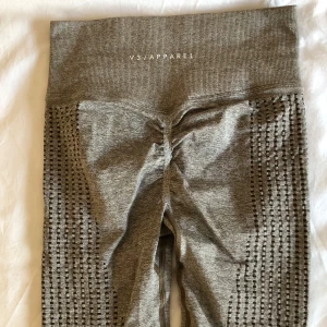 Grå leggings från V3 Apparel - Snygga leggings från V3 Apparel i ett stretchigt och bekvämt material. De har en hög midja och scrunch bak.  Perfekta för både träning och vardagsbruk. Bara höra av dig om du har några frågor 🌸
