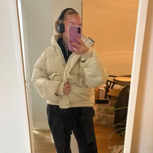 Beige pufferjacka - Säljer en supermysig beige pufferjacka i storlek M. Perfekt för kalla dagar med sin tjocka vaddering och stora huva. Jackan har en dragkedja framtill och är i mycket bra skick. Den är både snygg och praktisk för vintern! ❄️ obs lite sminkfläckar på! Men går säkert bort 