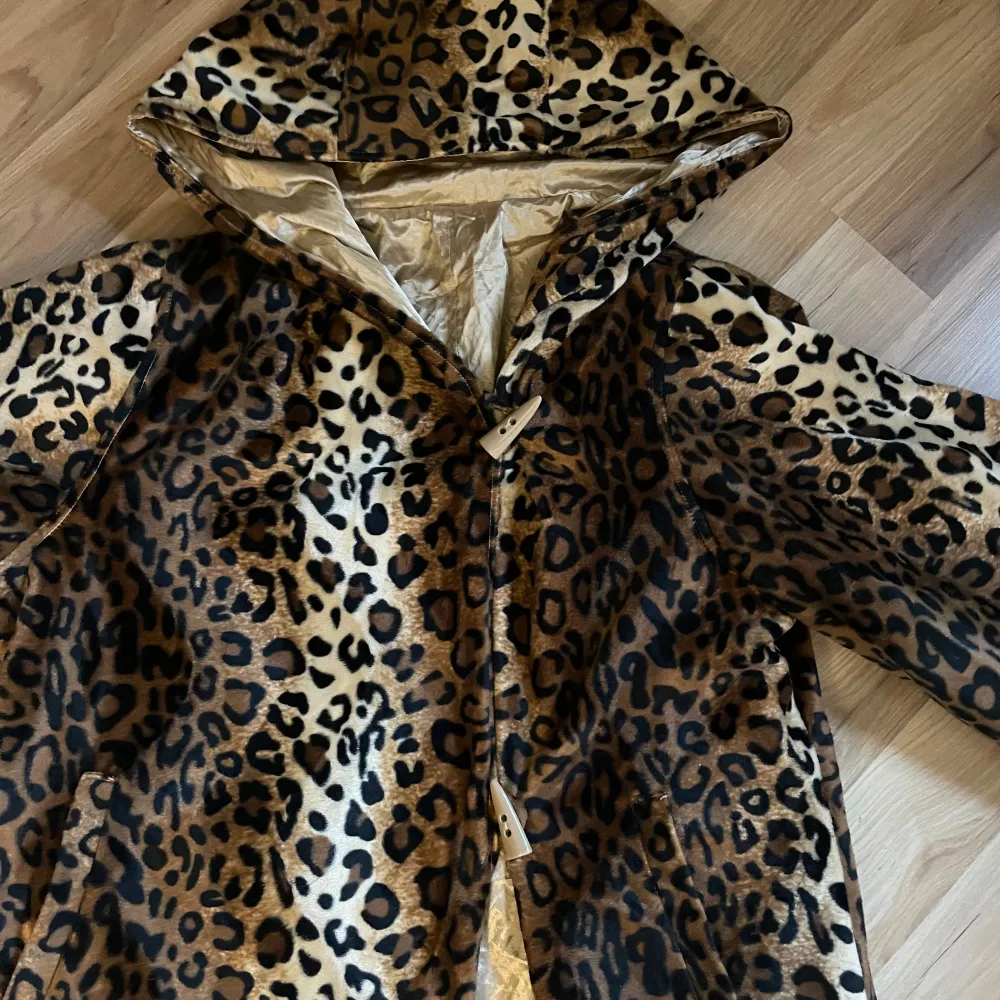 Säljer en supercool vintage leopardmönstrad pälsjacka med huva. Jackan har långa ärmar och stängs med knappar framtill. Fint skick och väldigt unik . Jackor.