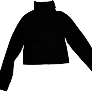 Svart ribbad polotröja från Bik Bok - Säljer en snygg svart ribbad polotröja från Bik Bok i storlek XS. Perfekt för kyliga dagar med sin höga krage och croppade stil. Tröjan är i mycket bra skick och passar både till vardags och fest. Ett måste i garderoben! 🖤