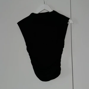 Set med kjol och topp - Svart topp med hög hals och linne med scrunch på sidorna i storlek xs, tillhörande lång kjol med scrunch på sidorna i storlek xs, Säljer tillsammans för 100 kr