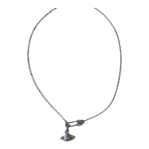 Vivienne Westwood Halsband  - Snyggt och unikt silverfärgat halsband med en cool säkerhetsnål som detalj. Hänget är format som en planet med gnistrande.                   köpte för 3 månader sedan från en butik i japan