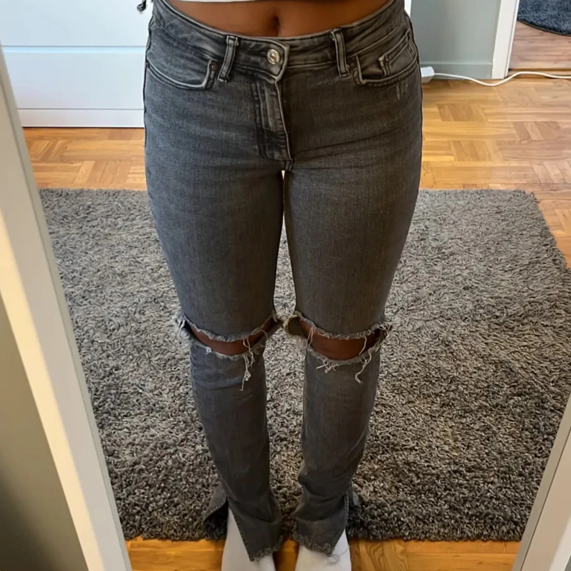Grå jeans med slitningar