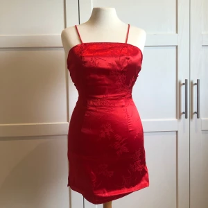 Röd miniklänning  - Super snygg klänning från pretty little thing. Snörning i ryggen och dragkedja. Använd endast en gång. Uppsydd i kanten längst ner.