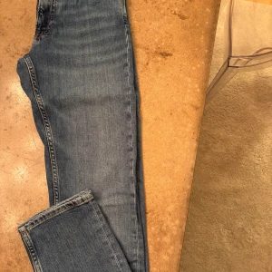 Blå jeans från GANT - Säljer ett par snygga blå jeans från GANT i slim fit. De är i bra skick och perfekta för  Klassisk design med fem fickor. Passar till alla säsonger och kan stylas med det mesta. Perfekt för dig som gillar en stilren look! 💙