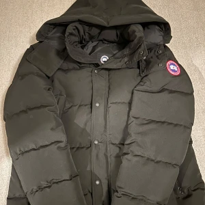 Svart dunjacka från Canada Goose - Säljer en svart Canada Goose Wyndham Parka som endast är använd förra vintern och är tyvärr för stor nu. Storlek XXL passar dig med XL. Nypris 13999kr