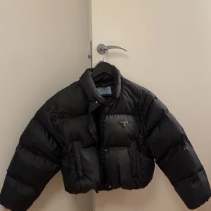 Prada convertable down jacket S - Storlek S Croppad dunjacka  Man kan ta av ärmarna för att göra den till en väst  Jag är 162cm och upplever den lite oversized, man får lätt plats med en hoodie   Använd 3 gånger förra vintern  Nypris 22000SEK 