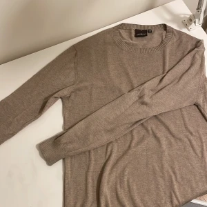 Beige tröja från Oscar Jacobsson! - Säljer en stilren beige tröja från Oscar Jacobsson i mycket bra skick. Den är långärmad och har en ribbad rund halsringning. Perfekt för både höst och vår, och passar till de flesta outfits. Supermjuk och bekväm!