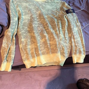 Gul tröja från Stone Island - Säljer en cool gul tröja från Stone Island. Den har ett unikt mönster och är i bra skick. Perfekt för både vår och sommar. Tröjan har långa ärmar och är superbekväm. Passar perfekt för en avslappnad stil! Storleken är XL men passar mig som har L