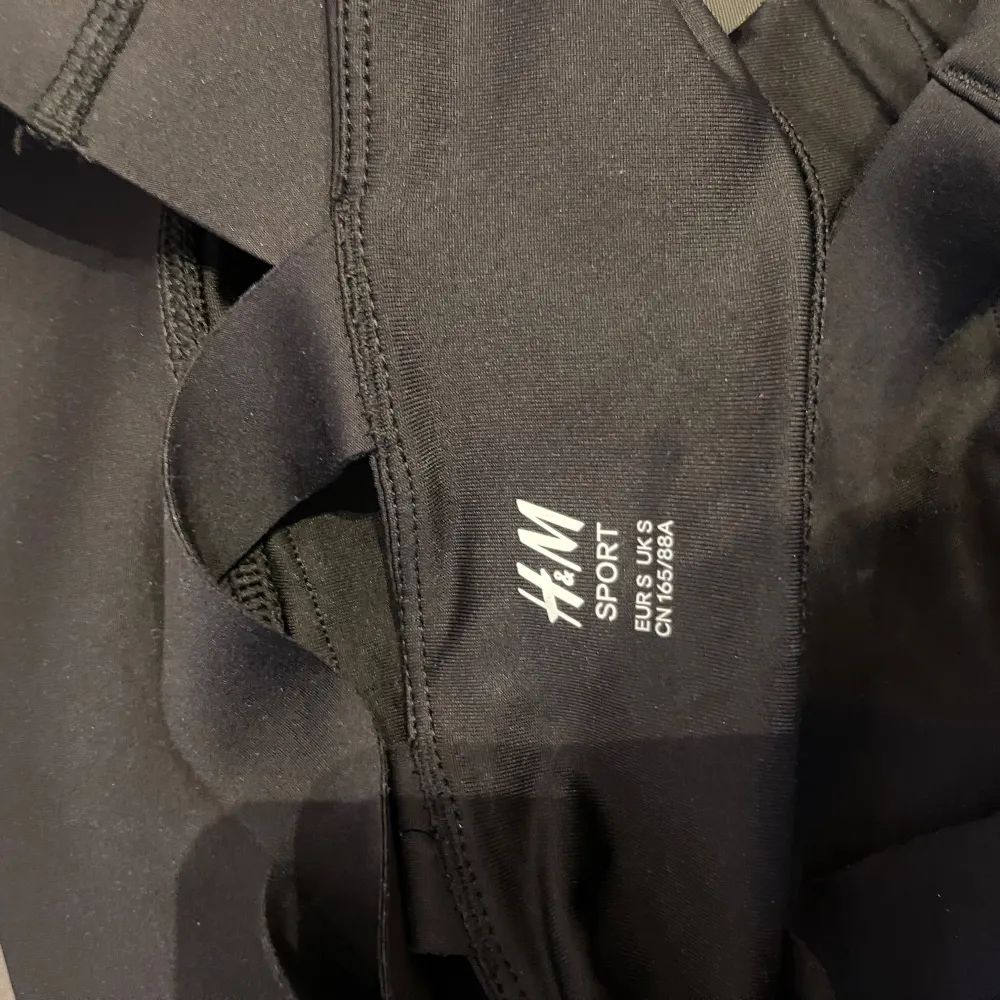 Säljer en svart sporttopp från H&M i storlek S. Toppen har en stilren design med korsade band i ryggen och är perfekt för träning. Materialet är stretchigt och bekvämt. Använd ett fåtal gånger och i mycket bra skick.. Yläosat.