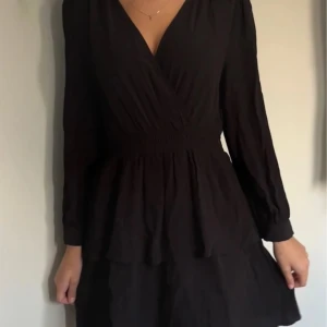 Svart Zara klänning  - Säljer en elegant svart omlottklänning med långa ärmar. Perfekt för både fest och vardag! Storlek xs köpt på zara