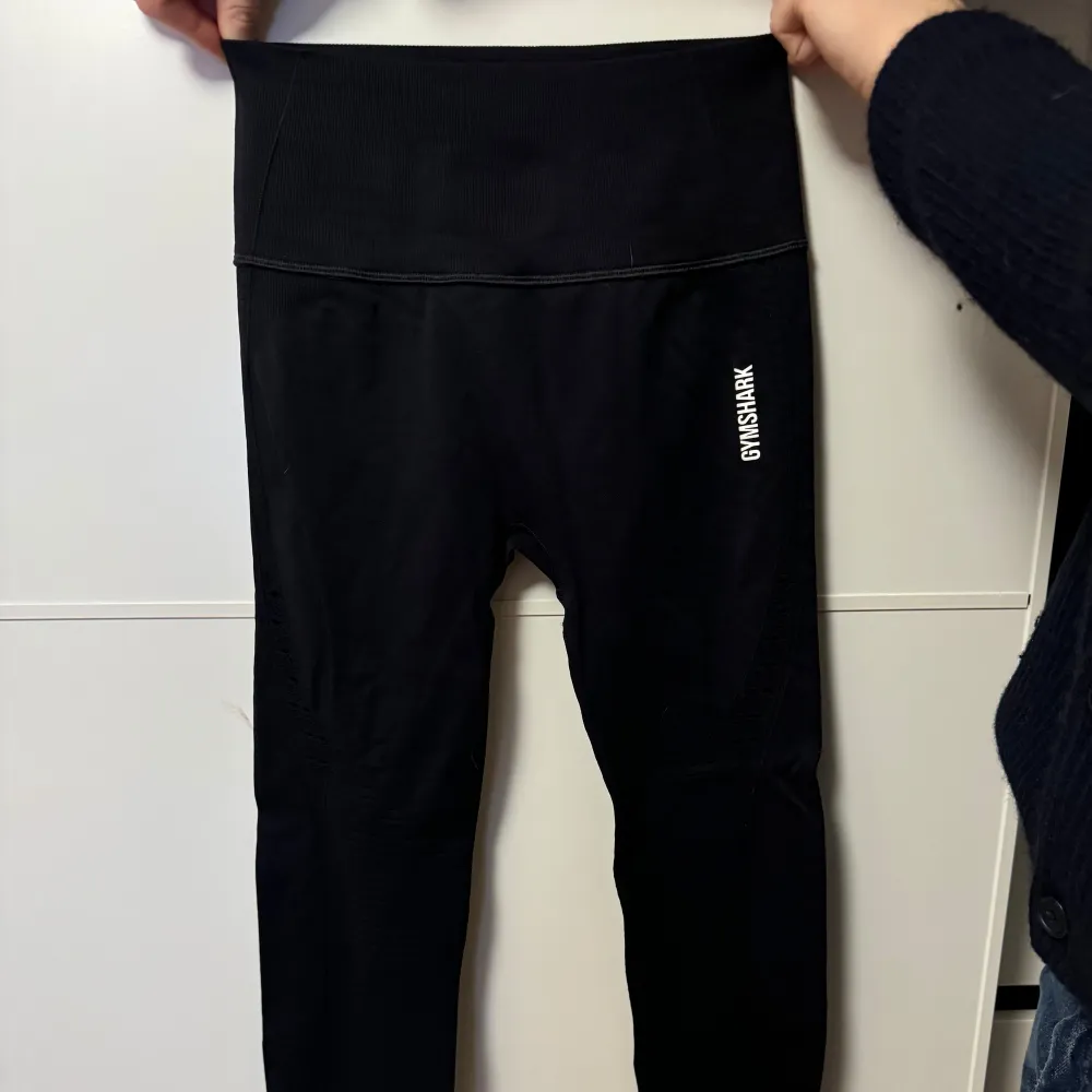 Säljer ett par svarta leggings från Gymshark i mycket bra skick. De är högmidjade och perfekta för träning. Materialet är stretchigt och bekvämt. Diskret Gymshark-logga på sidan och bak.. Sportswear.