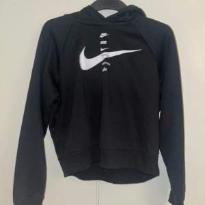 Säljer en svart hoodie från Nike i mycket bra skick. Den har en stor vit Nike-logga på framsidan och är perfekt för både vardag och träning. Hoodien har långa ärmar och en bekväm passform. Perfekt för höst och vinter!