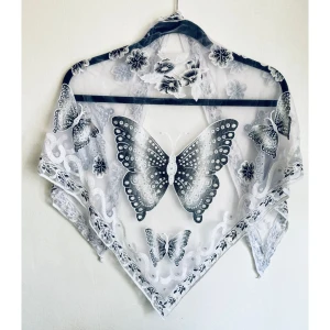 Vit & grå sjal, fjärilar, blommor, glitter, silver, scarf, romantisk, spets, broderi - Sjal i tunt nättyg med broderier, finns dragna trådar samt hål. Mått: 122x95x95 cm.