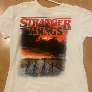 Stranger things T-shirt  - Stranger things T-shirt i storlek xss men oversied. Säljs för används inte mera. Gjord i bomull och ett litet håll slutet på ”loggan”. Några små fläckar som man inte tänker på. ***Tryck inte på köp nu****
