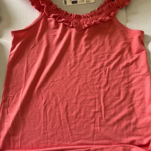 Esprit korall topp strl XS med prislappen  - Söt korall topp med volanger vid halsen och axlarna. Toppen är i en mjuk och bekväm kvalitet. Ordinarie pris 299  Storlek XS