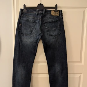 Diesel jeans herr  - Måttligt använda herr jeans i snygg modell och passform. Regular straight, mörkblå denim, knappgylf. W33/ L34. Nypris 1399SEK.