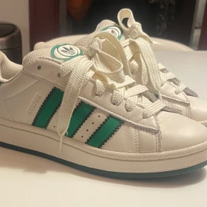 Adidas Campus grön vita - Adidas Campis gröna och vita i storlek 38. Jag säljer dom för de är för små. Dom är andvända men i fint skick. Köpta i London nypris 2200.
