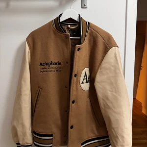 American Highschool Jacka - Den köptes på HM, ursprungliga priset är 800 kr, den är bra när man vill gå ute och det är vår eller höst. Den är i gott skick 