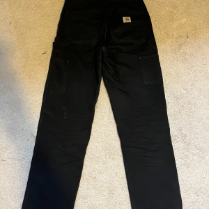 Carhartt Double Knee Pant 30x32 - Jättesköna byxor! Köpte de för ett par år sedan, använde de mycket, råkade göra hål i högra knät. Har några små fläckar. Storlek 30x32 Säljer de för att de inte längre passar mig. De sitter lite högre upp på midjan.